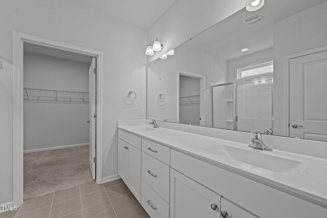 1047 Aberlour Ln, Burlington, NC 27215 - full bathroom featuring double vanity, visible vents, an enclosed shower, a sink, and baseboards