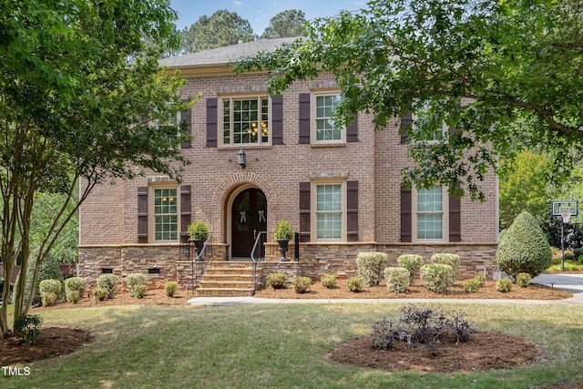 view of front of home with brick siding and a front lawn
