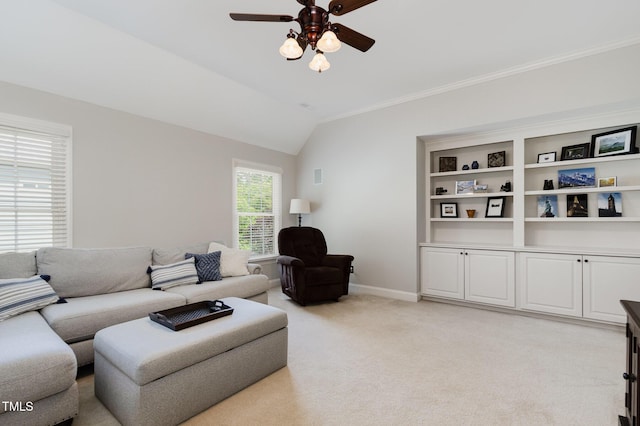 living area with light carpet, a ceiling fan, baseboards, vaulted ceiling, and ornamental molding