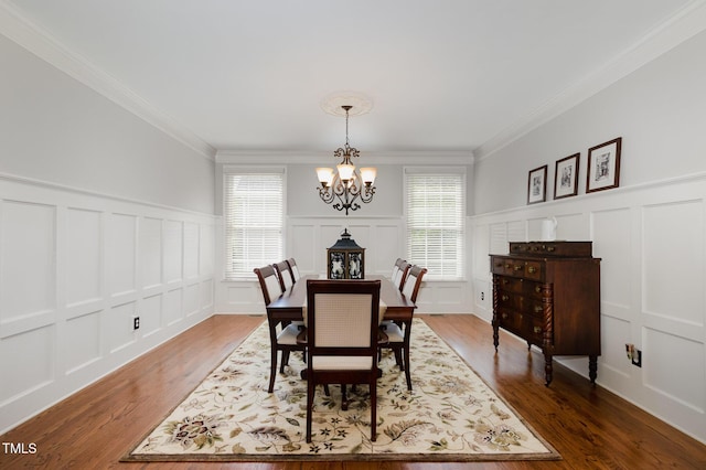 dining space featuring crown molding, a decorative wall, and a chandelier