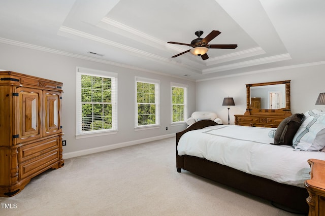 bedroom featuring crown molding, light colored carpet, a tray ceiling, and visible vents