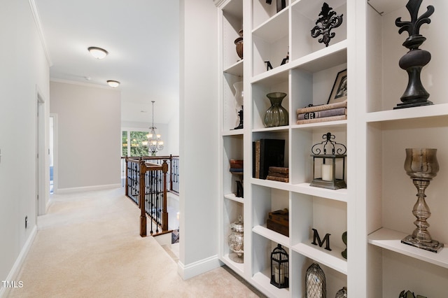 hallway with baseboards, carpet flooring, crown molding, and an upstairs landing