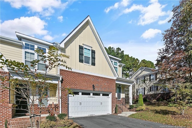 view of front facade featuring brick siding, board and batten siding, aphalt driveway, and an attached garage