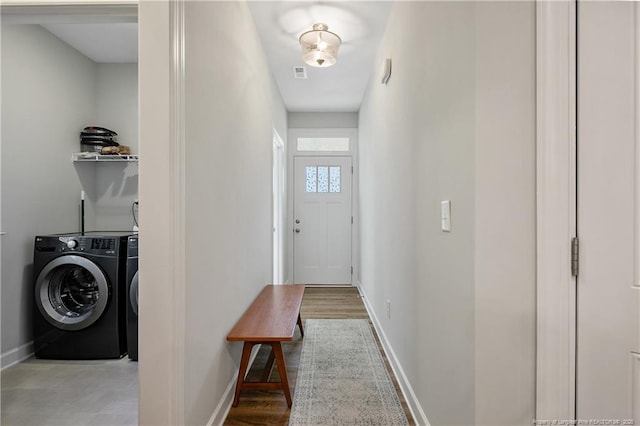 hall featuring washer and dryer, visible vents, and baseboards