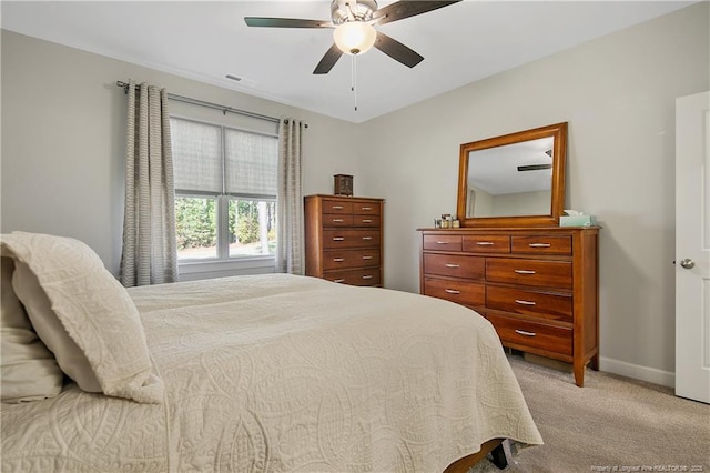 bedroom with a ceiling fan, visible vents, light colored carpet, and baseboards