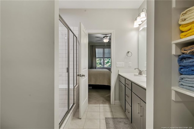 ensuite bathroom with tile patterned floors, a stall shower, double vanity, and a sink