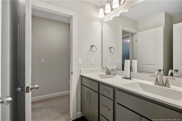 full bath with double vanity, baseboards, and a sink