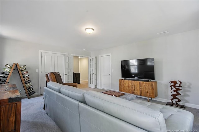 living area with baseboards, french doors, and light colored carpet