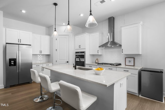 386 The Parks Dr, Pittsboro, NC 27312 - kitchen with stainless steel appliances, wall chimney exhaust hood, decorative backsplash, a sink, and white cabinetry