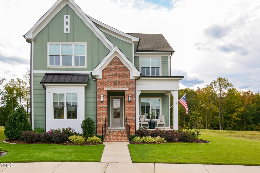 337 Sunset Hill Ln, Wendell, NC 27591 - craftsman inspired home featuring brick siding, board and batten siding, a front yard, and covered porch