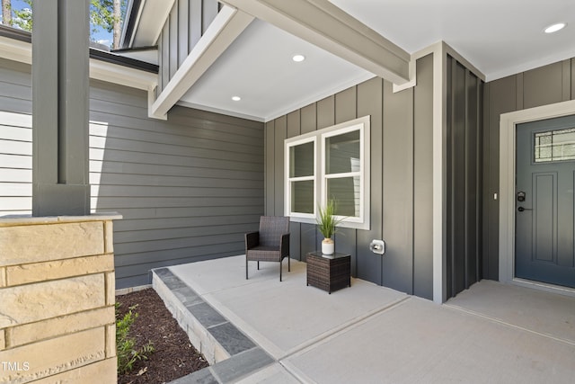property entrance with board and batten siding and covered porch