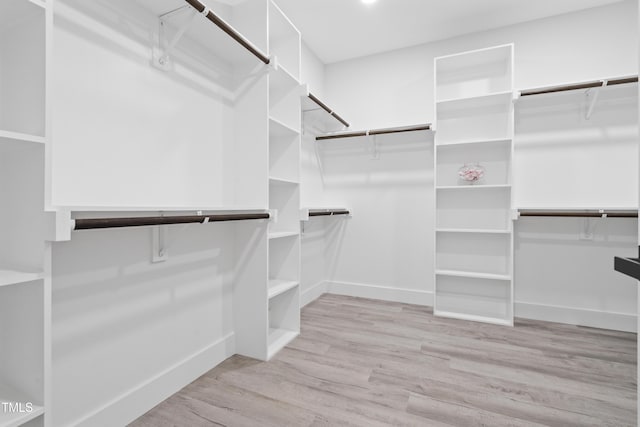 walk in closet with wood finished floors