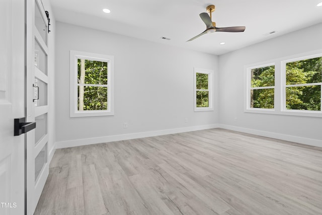 spare room with baseboards, visible vents, a healthy amount of sunlight, and light wood finished floors