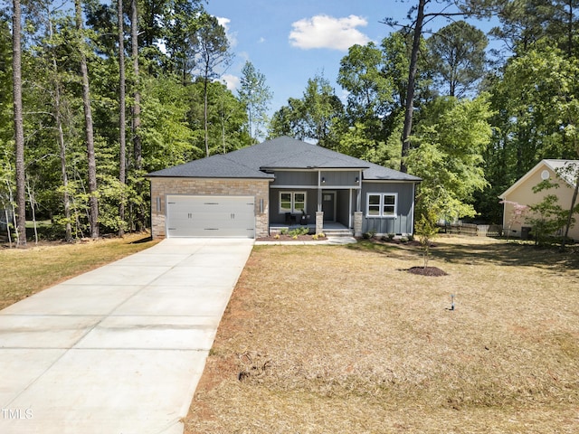 view of front of house featuring a shingled roof, a garage, board and batten siding, a porch, and driveway