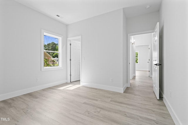 interior space featuring baseboards, light wood finished floors, and a wealth of natural light