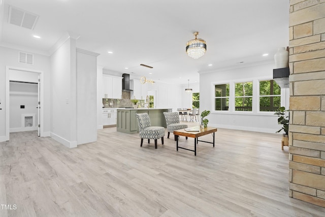 living area featuring visible vents, ornamental molding, baseboards, recessed lighting, and a notable chandelier