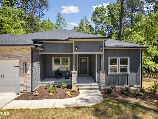 prairie-style home with roof with shingles, board and batten siding, and a porch