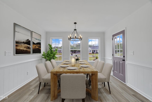 112 Edmondson Dr, Willow Springs, NC 27592 - dining space featuring light wood finished floors, a notable chandelier, wainscoting, and a decorative wall