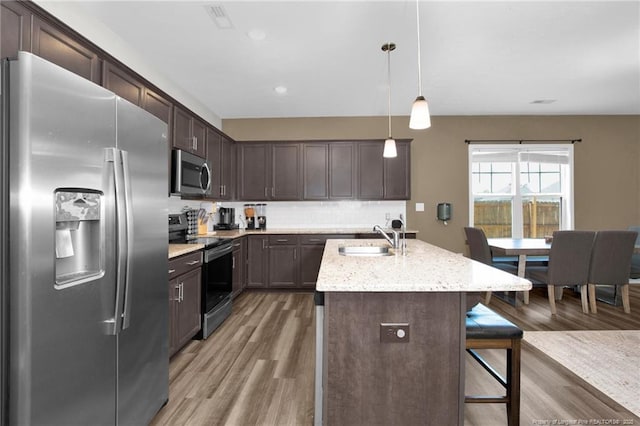 504 Loom Dr, Fayetteville, NC 28306 - kitchen featuring stainless steel appliances, a sink, light wood finished floors, dark brown cabinets, and recessed lighting