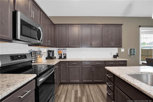 504 Loom Dr, Fayetteville, NC 28306 - kitchen with stainless steel appliances, light wood-style floors, dark brown cabinets, and decorative backsplash
