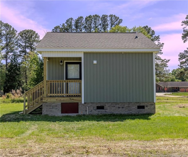 view of side of property with crawl space, stairs, and a yard