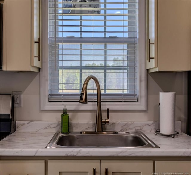 details with a sink and white cabinetry