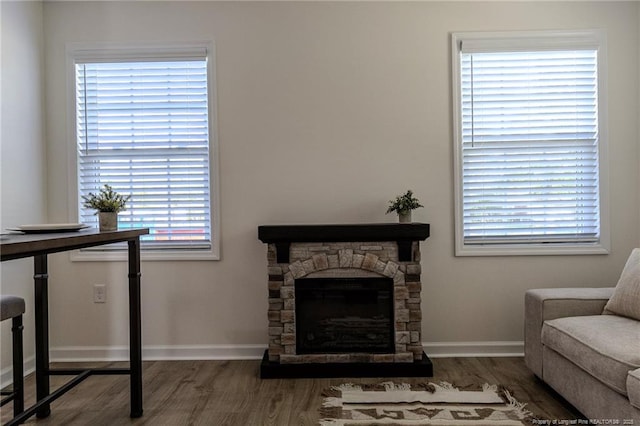living area featuring a fireplace, wood finished floors, and baseboards