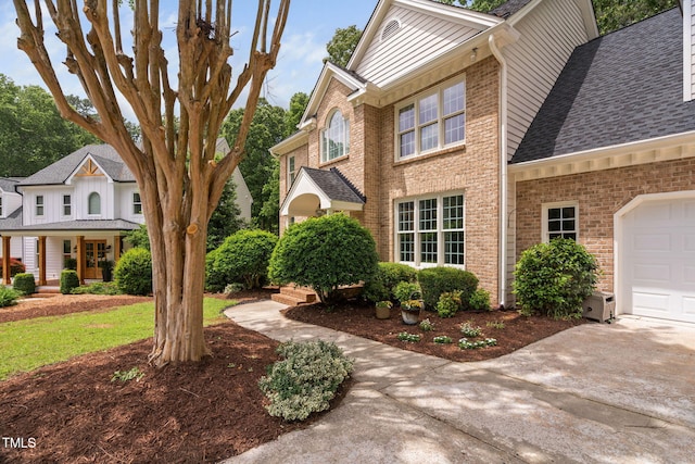 108 Nimbus Ct, Cary, NC 27513 - view of property exterior with brick siding, driveway, roof with shingles, and a garage