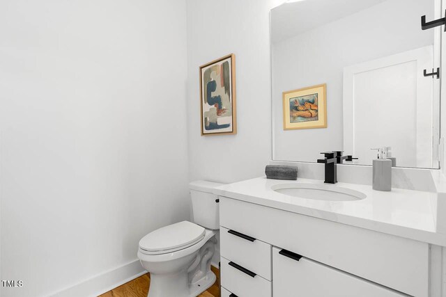 211 W Coporation, Durham, NC 27701 - half bathroom with vanity, toilet, wood finished floors, and baseboards