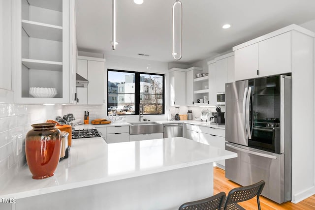 211 W Coporation, Durham, NC 27701 - kitchen featuring appliances with stainless steel finishes, a sink, open shelves, a peninsula, and backsplash