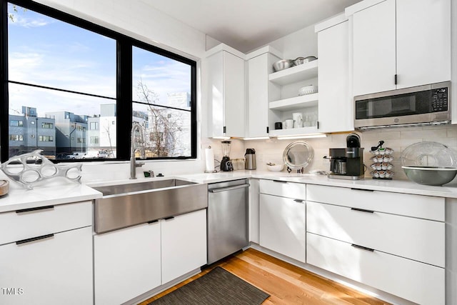 211 W Coporation, Durham, NC 27701 - kitchen featuring stainless steel appliances, open shelves, light countertops, and light wood-type flooring