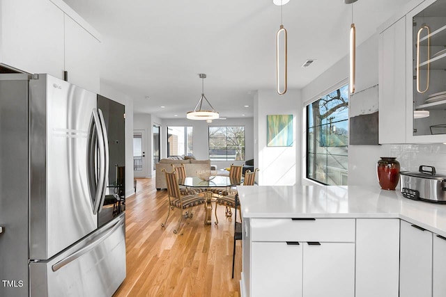 211 W Coporation, Durham, NC 27701 - kitchen with freestanding refrigerator, a peninsula, light countertops, light wood-type flooring, and plenty of natural light