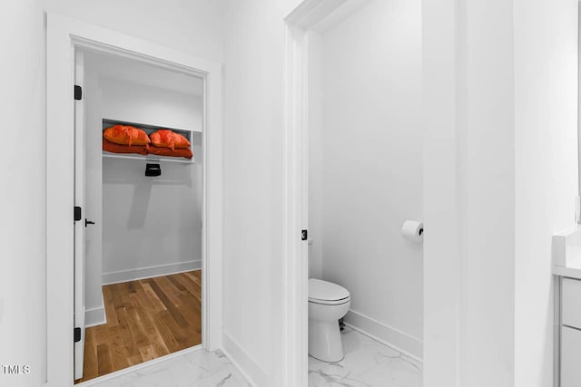 211 W Coporation, Durham, NC 27701 - bathroom featuring marble look tile flooring, toilet, and baseboards