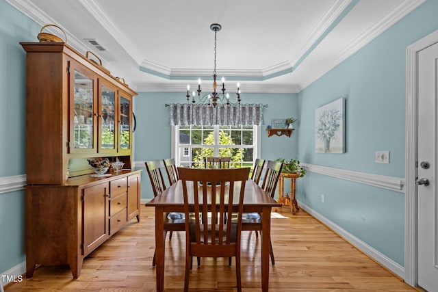 1813 Turning Plow Ct, Holly Springs, NC 27540 - dining area featuring a chandelier, a raised ceiling, light wood-style floors, and ornamental molding