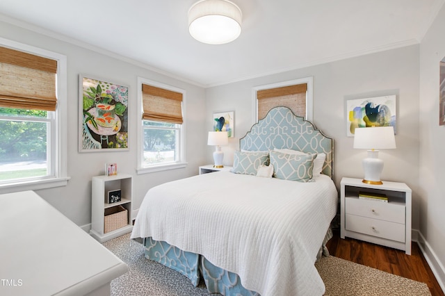 bedroom featuring crown molding, baseboards, multiple windows, and wood finished floors