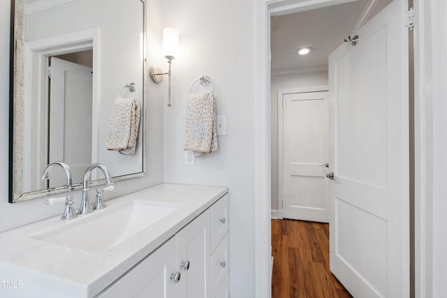 bathroom featuring crown molding, vanity, recessed lighting, and wood finished floors