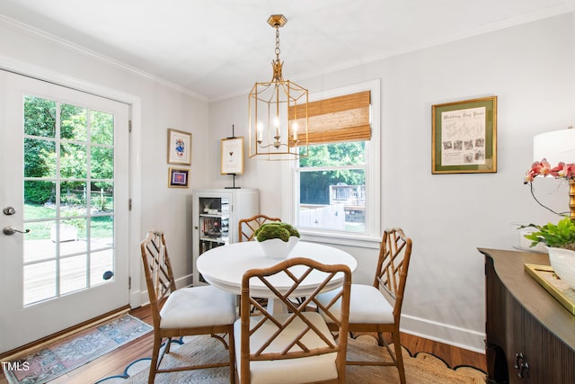 dining space featuring an inviting chandelier, baseboards, wood finished floors, and a healthy amount of sunlight