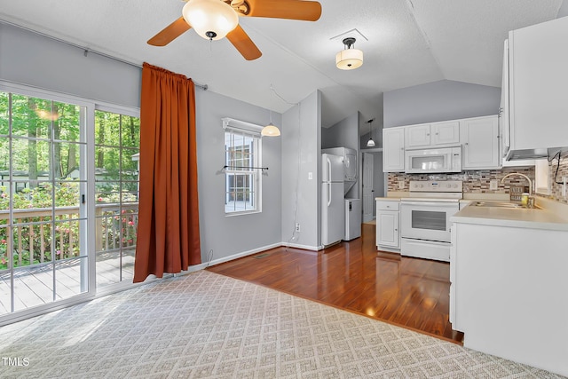 107 Piquot Dr, Louisburg, NC 27549 - kitchen with dark wood-style floors, a sink, vaulted ceiling, white appliances, and light countertops
