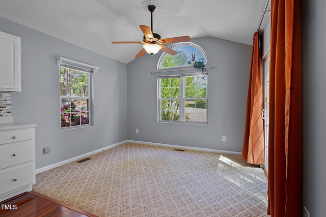 107 Piquot Dr, Louisburg, NC 27549 - spare room featuring vaulted ceiling, a ceiling fan, a textured ceiling, baseboards, and visible vents