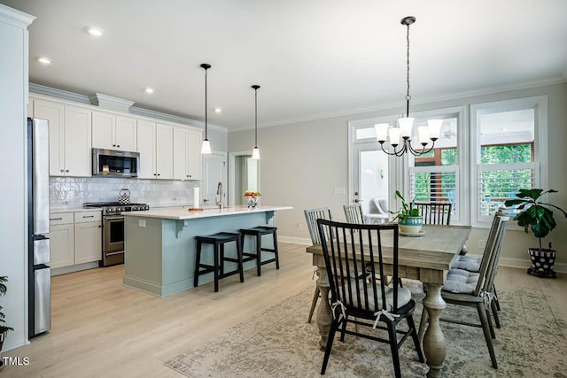 83 Vandalia Ave, Chapel Hill, NC 27516 - dining space featuring light wood-style floors, baseboards, ornamental molding, and an inviting chandelier