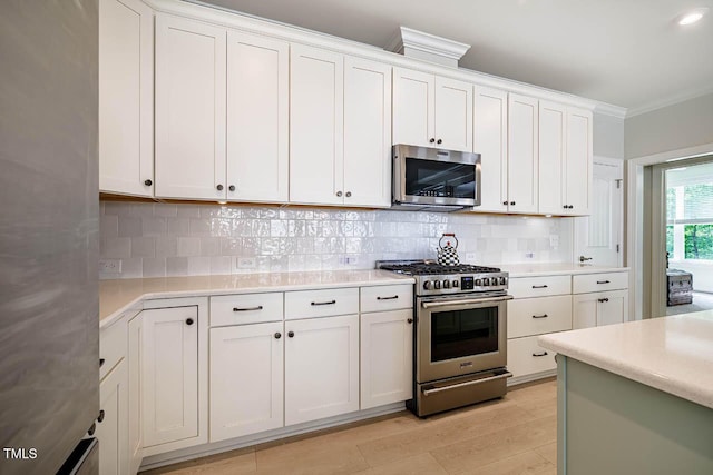 83 Vandalia Ave, Chapel Hill, NC 27516 - kitchen with stainless steel appliances, light countertops, backsplash, ornamental molding, and white cabinetry