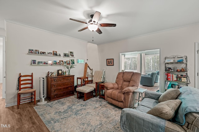 living area featuring wood finished floors, a ceiling fan, and ornamental molding