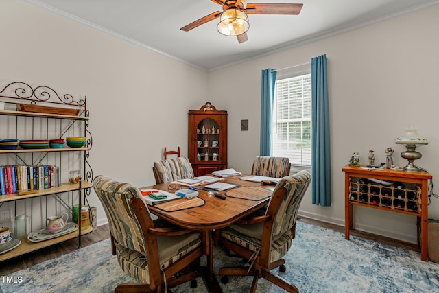 dining room with baseboards, wood finished floors, ceiling fan, and ornamental molding