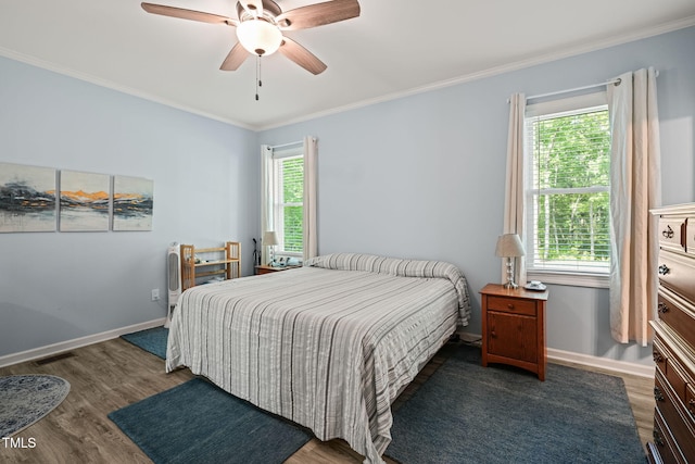bedroom featuring baseboards, ornamental molding, ceiling fan, and wood finished floors