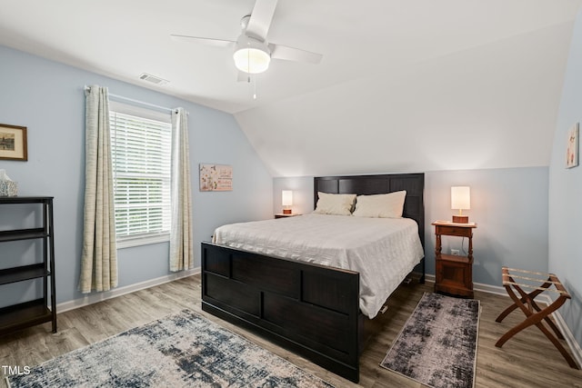 bedroom with wood finished floors, ceiling fan, vaulted ceiling, and baseboards