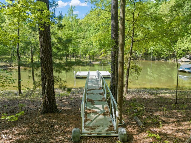 dock area featuring a forest view and a water view