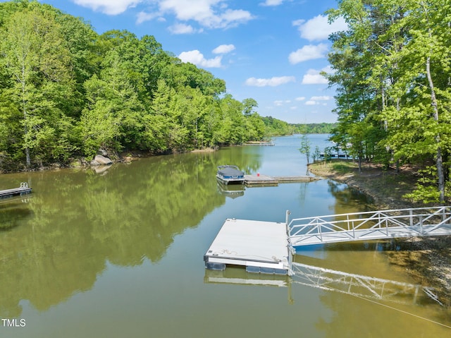 dock area featuring a water view and a wooded view