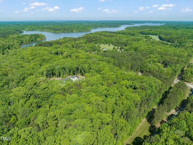 birds eye view of property featuring a wooded view and a water view