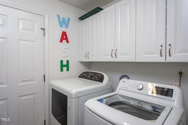 clothes washing area featuring cabinet space and washing machine and dryer