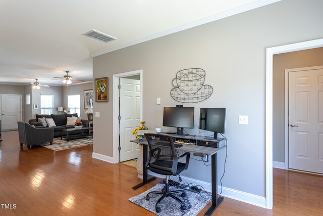 office with ornamental molding, light wood-type flooring, baseboards, and a ceiling fan